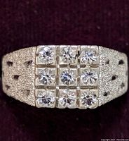 Close-up photo of the sterling silver ring showing the 3x3 square pattern of clear stones and textured band with cutouts.