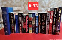 Front view of all 15 suspense and thriller novels with visible titles and authors on spines, arranged in a row.