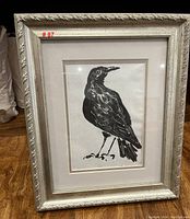 Framed black ink or watercolor drawing of a crow from front view showing the full artwork and frame.