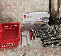 Full lot including three-piece boxed stoneware cooking dish set, red plastic basket, black wire basket, can opener, and red-handled utensils