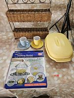 Photo showing all items in the lot including the Tupperware pasta server, two-tier basket, cooking basket, and two ceramic espresso cup sets.