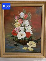 Framed oil painting of a floral arrangement with a variety of colorful roses and greenery on a dark background