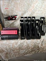 View of ten black plastic magazine holders in a row, showing open design for easy magazine storage.