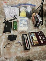 All items as a group including pads, glasses, pens, grooming kit, sponges, and books.