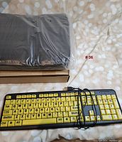 High-visibility keyboard with large yellow keys alongside the new laptop case to show both items in the lot