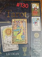 Photo of the sealed Tarot card deck box showing colored reference cards The Empress, The Sun, and The Magician, with text detailing 78 specially commissioned cards and a 64-page illustrated book included.