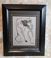 Black framed Picasso-style art print on a bokeh background.