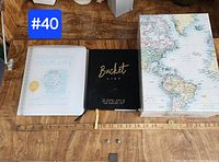 Two life improvement journals shown: "Designing Your Life" and "Bucket List" placed side by side on a wooden surface with a ruler below.