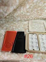 Photo showing all trays and the deviled egg tray lid laid on a beige patterned cloth background.