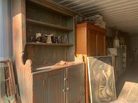 Front view of cabinet showing two open shelves and two-door base with green and red scraped paint patina