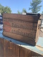 Side view showing stencil lettering 'Extra Quality Granulated' and red circular sugar logo on wooden slats.