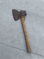 Photo of the full hatchet showing wooden handle and metal blade with scalloped edge.