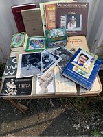 Overview of assorted books, vinyl records, 8x10 photos, and a colorful map on a small table