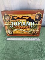 Front view of the Jumanji board game wooden box with colorful game-themed artwork featuring characters and animals.