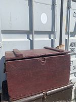 Side view showing the oxblood color, hinged top, and cleat latch.