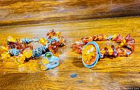 Photo showing amber bead bracelets and silver rings with amber and multicolored stones.