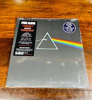 Front view of sealed Pink Floyd The Dark Side of the Moon vinyl LP with iconic prism artwork and rainbow spectrum.