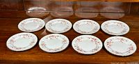 Eight Paragon Victoriana Rose luncheon plates arranged in two rows displaying floral pattern and gilded edges.