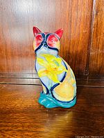 Side and back view of the porcelain cat figurine showing detailed floral tube-lined painting and colors on the cat's body, signed Old Tupton Ware.