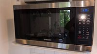 Full front view of the Samsung microwave showing the digital display at 6:55 and control panel on right side.