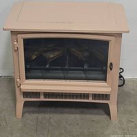 Front view of cream-colored Duraflame electric stove with closed glass door showing artificial logs inside.