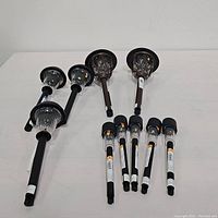 10 assorted black solar outdoor path lights arranged side by side showing two types: lattice cage and smooth topped models