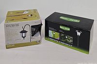 4-Pack Classic Coach Dual Use Walk Lights and 8-Pack Beau Jardin Solar Outdoor Garden Path Lights boxed sets.