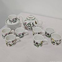 Full view of the 17-piece tea set including teapot, cups, and saucers arranged on a white surface.