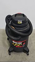 Shop Vac QSP Quiet 6 gallon wet/dry vacuum showing side and hose coiled around it.