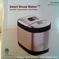 Front of breadmaker box showing stainless steel appliance image and product branding