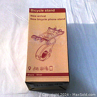 Box front showing illustration of the bicycle phone mount with color options black or silver and usage icons for bicycle, motorcycle, and phone.