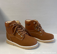 Front-side view of the tan kids ankle boots showing laces, padded collar, and sole