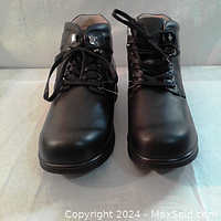 Front view of the pair of black leather men's ankle shoes showing smooth toe area, laces, and overall design.