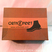 Closed OrthoFeet branded cardboard shoebox with logo and website on top.