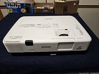 Top view of Epson H474A projector showing branding and lens area
