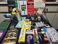 Overall view of lot with markers bucket, stationery boxes, laminating pouches, punches, journals and accessories