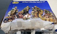 Photo of packaging box featuring image of the 10 piece porcelain nativity set and visible wear and damage to the box.