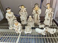 Full set of Nativity figures arranged together including Mary, Joseph, Baby Jesus, three Wise Men, shepherd, and animals on a rack.