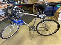 Side view of the complete bike showing frame, tires, pedals, seat, and blue helmet