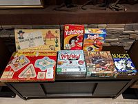 Overview of seven board and card games including vintage Have Gun Will Travel, Yahtzee, Jenga Max, Pictureka!, Super Zigograph, Triple Run Danger Chase, and Magic: The Gathering cards