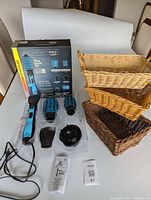 Conair InfinitiPro dryer brush handle with four attachments and three wicker storage baskets arranged on a surface with product box in the background.