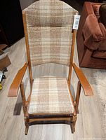 Front view of folding rocking chair showing wooden armrests and plaid fabric padded seat and backrest.