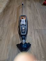 Full upright view of Hoover SteamScrub Pro Pet steam mop showing triangular mop head and handle.