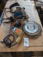 Mastercraft circular saw with attached blade, drill with buffing attachment, and two circular saw blades displayed on a wooden surface.