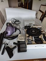 Purple Shark steamer with power cord, multiple cleaning attachments including extension tubes and brushes, and a cloth towel.