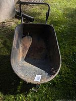 Top view of metal wheelbarrow showing rusted bucket and wear on metal surface