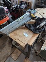 Side view of the Yardworks electric leaf blower including the silver blower tube and attached black collection bag with Yardworks logo.