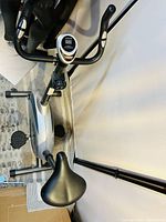 Top-down view of the stationary cardio bike showing seat, handlebars with digital screen, and base.