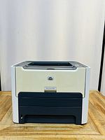 Front view of the HP LaserJet 1320 printer showing the model label and paper output area.