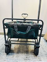 Front view of the rolling cart showing fabric body, mesh pockets and metal frame with wheels.